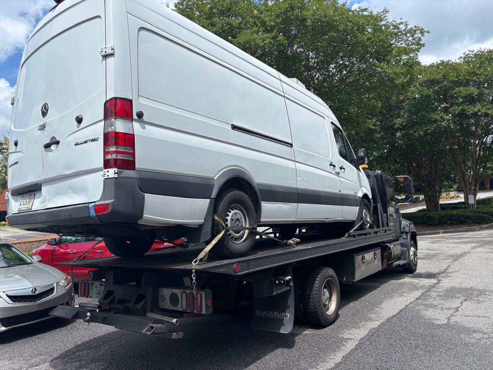 Move Any Car LLC towing a white cargo van