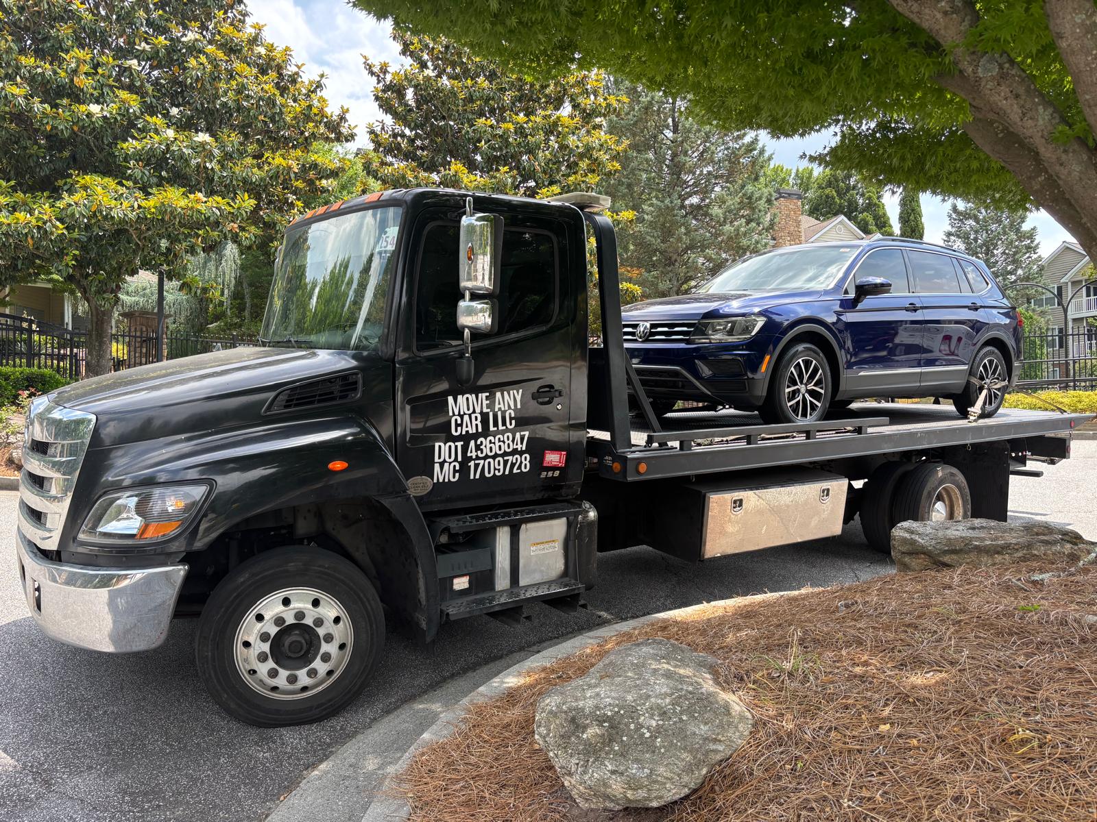 Move Any Car LLC towing a blue SUV in a residential area